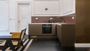 Une cuisine moderne équipée d’un four encastré, d’une machine à café et d’un évier.
