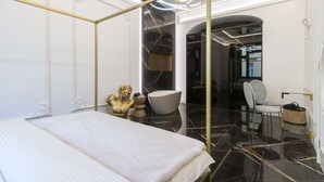Une chambre à coucher moderne avec un lit à baldaquin, un sol en marbre et un grand miroir.