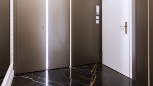 Un ascenseur moderne au design épuré, doté d’une finition métallique et d’un sol réfléchissant.