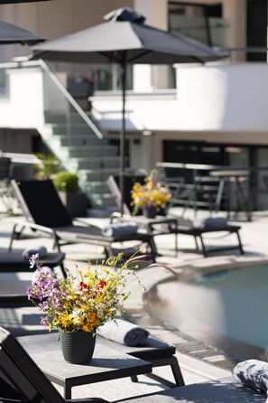 Piscine extérieure en saison, parasols, chaises longues