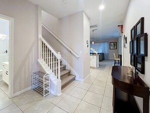 A modern interior with a staircase, a kitchen area, and a dining space.