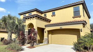 A two-story house with a beige facade, a tiled roof, and a garage. - Magical Express: Private Pool & 24/7 Support (Davenport)