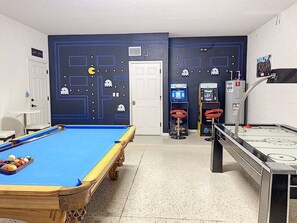 Une table de billard avec des billes, une queue de billard et une table de billard recouverte d’un feutre bleu.