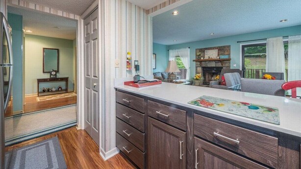 Une cuisine moderne dotée d’un grand îlot central, de meubles en bois et donnant sur l’espace de vie.