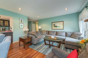 A living room with a sofa, coffee table, and a lamp. - Bent Creek 28 at Rumbling Bald (Lake Lure)