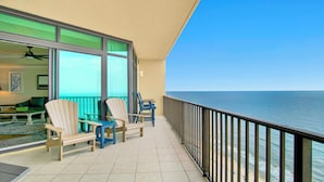 Ein Balkon mit Blick auf das Meer, ausgestattet mit zwei Holzstühlen und einem kleinen Tisch.