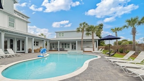 A swimming pool with lounge chairs, a patio area, and a house in the background. - Poseidon's Palace | Private Pool/Spa | 6-Seater Golf Cart | Game Room (Destin)