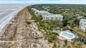 Ein Strandhotel mit mehreren Gebäuden, einem Pool und direktem Zugang zum Strand.