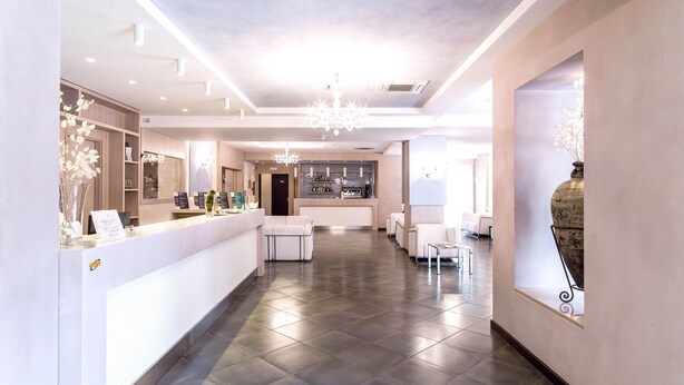 Un moderno vestíbulo de hotel con una recepción, zona de estar y un bar.