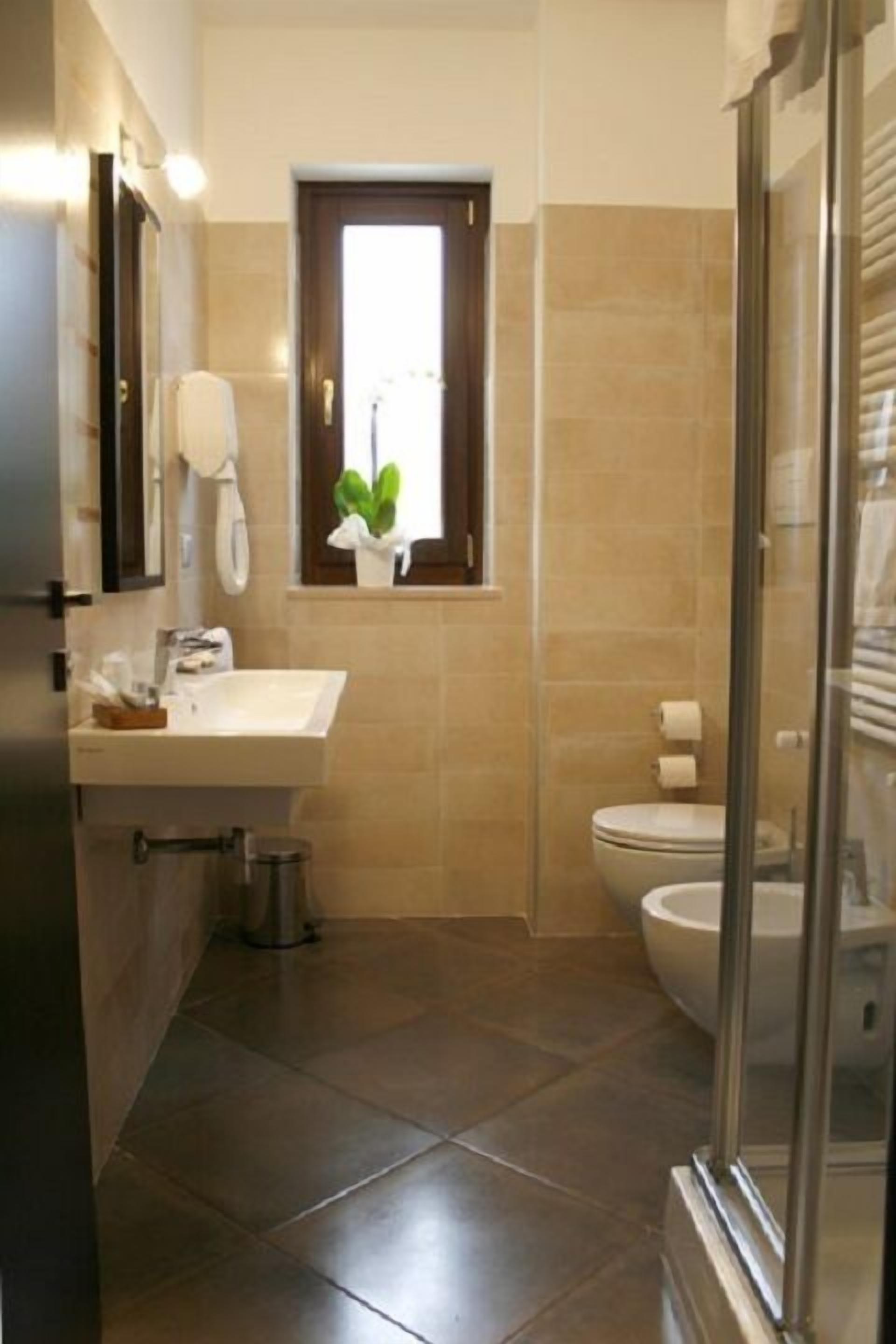 Ein modernes Badezimmer mit Waschbecken, Spiegel und Toilette.