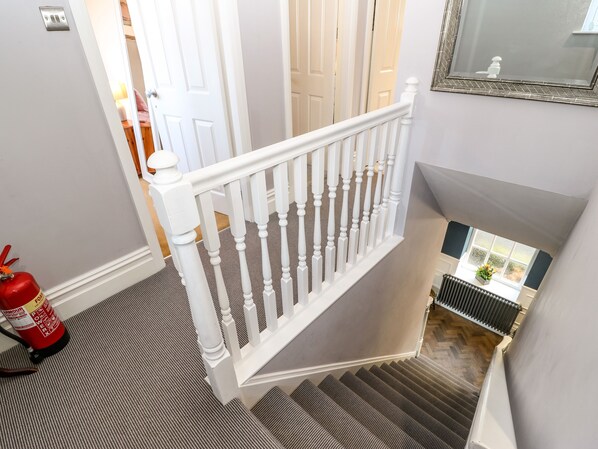 Eine Treppe mit weißen Balustraden und einem Feuerlöscher auf der linken Seite.
