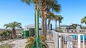 A pool area with a sign indicating surveillance and a no dogs policy. - 1BR Fort Morgan Condo | Gulf Views + Pool (GULF SHORES)