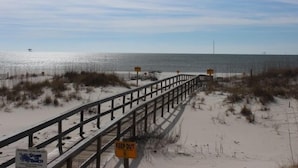 A beach with a wooden boardwalk and a 'KEEP OUT' sign. - 1BR Fort Morgan Condo | Gulf Views + Pool (GULF SHORES)