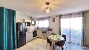 Cocina moderna con zona de comedor, que incluye microondas, horno y lavamanos.