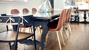Un espace repas comprenant une table ronde, des chaises et un luminaire suspendu.