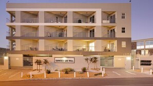 A multi-story hotel with a flat facade, balconies, and a sign reading "Sunset on Hill". - Sunset On Hill 3 (Cape Town)