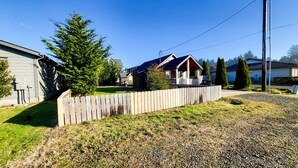A residential area with houses, a wooden fence, and a clear sky. - Bay Street Retreat - Waldport (Waldport)