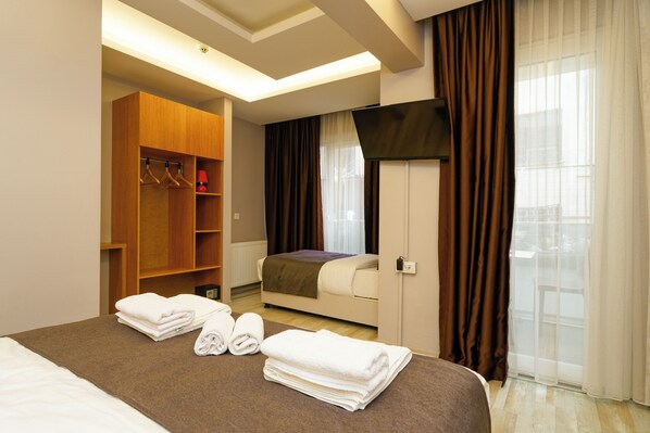 Relax in a cozy space with a made bed, wardrobe, and flat-screen TV.