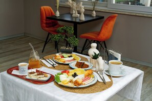 Enjoy a meal in style with a beautifully set table featuring a variety of dishes and a potted plant.