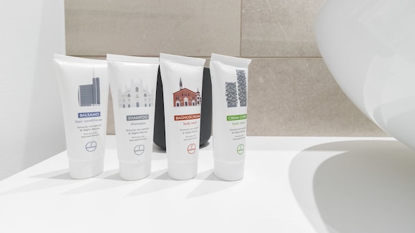 Cuatro productos de aseo sobre una superficie blanca en un baño.