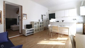 A modern, open-plan living space with a kitchen, dining area, and a small seating area. - Italianway Easy - Bligny 64 (Milan)