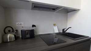 A modern kitchen with a kettle, toaster, and sink. - Italianway Easy - Ciaia 6 A (Milan)