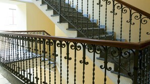 A staircase with ornate black metal railings and a wooden handrail. - Cirillo 14 - Apartment Milan (Milan)