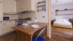 A compact hotel room with a kitchenette, a dining area, and a bed. - Cirillo 14 - Apartment Milan (Milan)