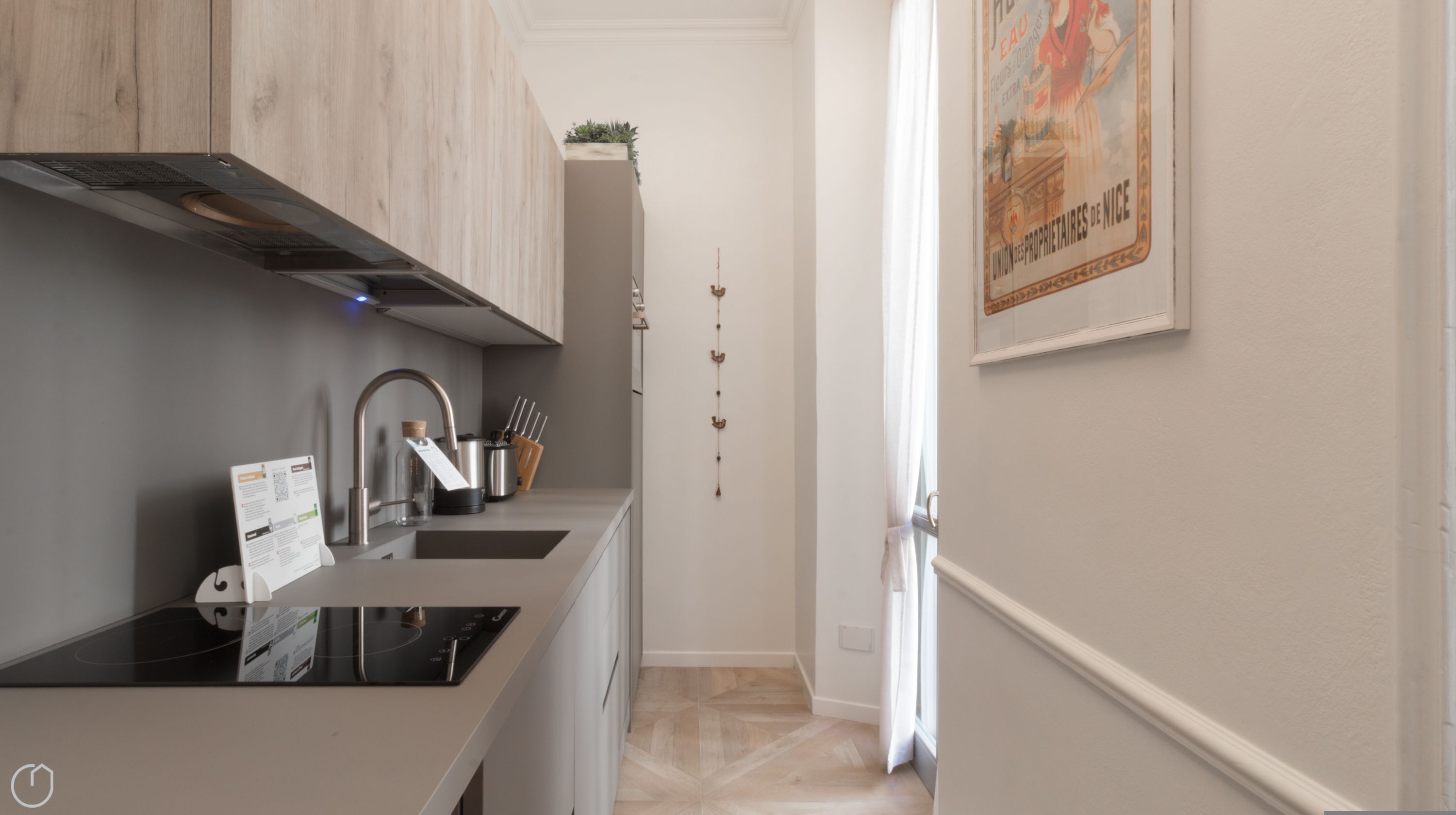 A modern kitchen with a built-in stove, stainless steel sink, and wooden cabinets.