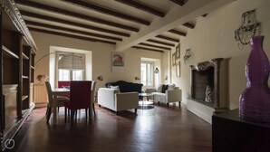A spacious living room with wooden floors, a fireplace, and a dining area with a table and chairs. - Italianway Easy - Argelati 12 Bilo (Milan)