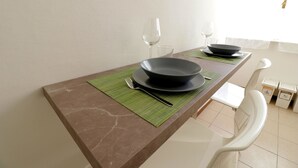 A dining table with a dark marble top, two black plates, a fork, and two wine glasses. - Italianway Comfort - Bergognone 47 B (Milan)