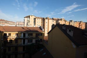 Vista de una zona residencial con edificios de varios pisos, balcones y cielo despejado.