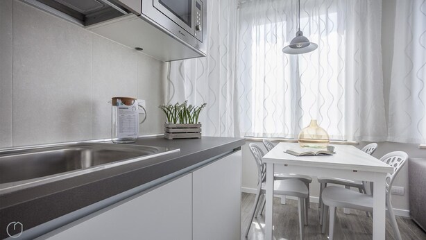A modern kitchen with a built-in microwave, a kettle, and a small potted plant. - Italianway Easy - Cadorna 10 Mono A (Milan)