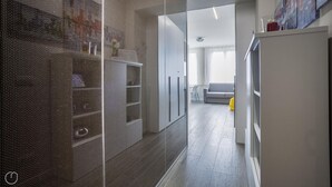A modern interior with a glass partition, a grey sofa, and a yellow bag on the floor. - Italianway Easy - Cadorna 10 Mono A (Milan)