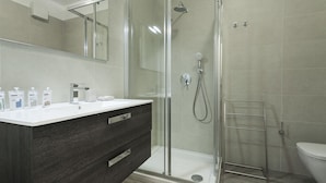 A modern bathroom with a glass shower enclosure, a white sink with dark wood cabinetry, and a toilet. - Italianway Easy - Cadorna 10 Mono B (Milan)