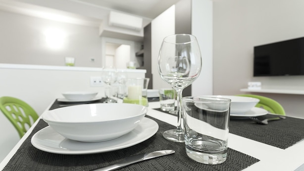 A modern dining area with a white table set for two, including plates, bowls, glasses, and cutlery. - Italianway Easy - Cadorna 10 Mono B (Milan)