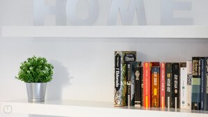 A bookshelf with books and a potted plant. - Italianway Easy - Cerano 15 (Milan)