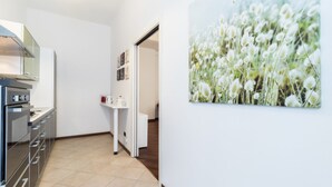 A modern kitchen with stainless steel appliances, a white countertop, and a tiled floor. - Italianway Easy - Cristoforo Colombo 1 (Milan)