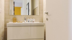 A bathroom with a white sink, a mirror, and a door. - Mono A (Milan)