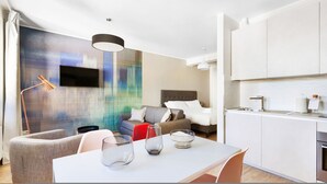 A modern hotel room with a bed, a sofa, a dining table, and a kitchen area. - Mono B (Milan)
