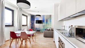A modern kitchen with a built-in oven and a large stainless steel range hood. - Mono B (Milan)