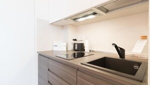 A modern kitchen with a stainless steel sink, a black coffee machine, and a white paper on the counter. - Italianway Easy - Ciaia 6 B (Milan)