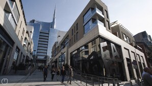 Eine moderne Stadtstraße mit zeitgenössischer Architektur, darunter ein markanter Wolkenkratzer.