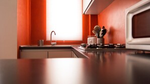 A kitchen with a modern design, featuring a stainless steel sink, a gas stove, and a microwave. - Italianway Easy - Corso Lodi 78 (Milan)