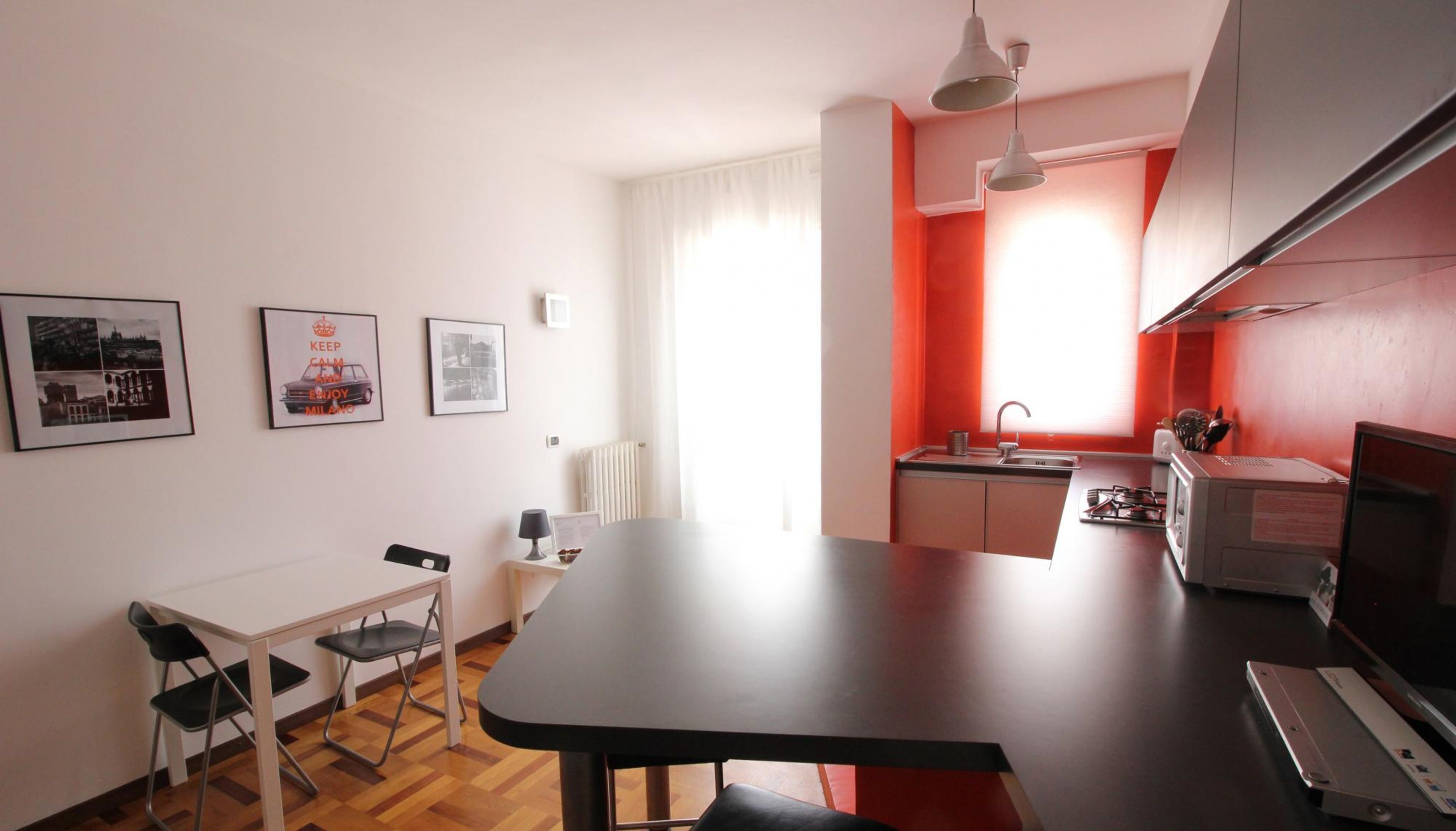 Eine kompakte Küche mit Essbereich, Kühlschrank, Mikrowelle und Herd.