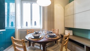 A dining area with a round table set for four, surrounded by wooden chairs. - Mi-clod9a3 - Corso Lodi 9 (Milan)