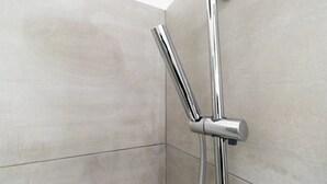 A corner of a bathroom with a chrome showerhead and handle. - Italianway Easy - De Cristoforis 5 (Milan)