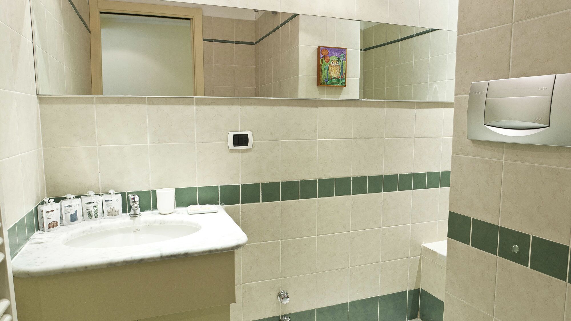 A bathroom with a sink, mirror, and hand dryer.