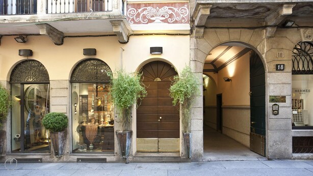 A building facade with three arched entrances, each with a number above the door. - Italianway Easy - Fiori Chiari 20 (Milan)