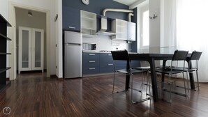 Una cocina moderna con comedor, que incluye un refrigerador, microondas y armarios.